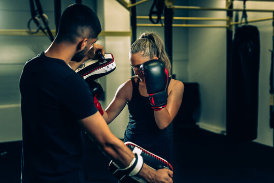 Woman Boxing With Her Trainer In Gym