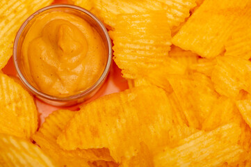 Crispy, delicious potato chips with mustard sauce. Close up.