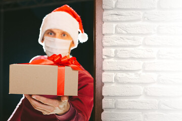 courier delivers a gift on Christmas Eve in a mask from the coronavirus