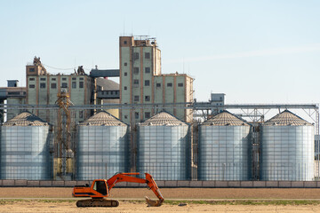 Fototapeta premium silver silos on agro manufacturing plant for processing drying cleaning and storage of agricultural products, flour, cereals and grain. Large iron barrels of grain. Granary elevator