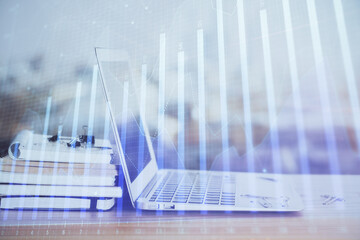 Forex graph hologram on table with computer background. Multi exposure. Concept of financial markets.