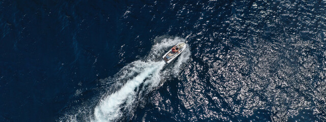 Aerial drone ultra wide photo of jet ski watercraft cruising in high speed in deep blue open ocean...