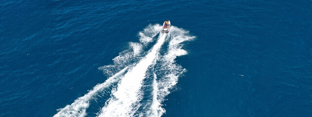 Aerial drone ultra wide photo of jet ski watercraft cruising in high speed in deep blue open ocean sea