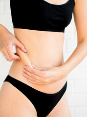 Folds on the female belly. Photo has noise effect and selective focus