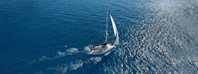 Aerial drone ultra wide photo of beautiful sailboat sailing in tropical exotic bay with emerald...