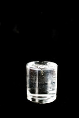 Full glass of water on a black background. Photo taken with selective focus and noise effect