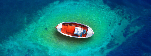 Aerial top view ultra wide photo of traditional wooden fishing boat near Aegean island destination...