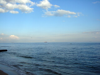 Obraz premium Picture of rainbow colors of the sunset reflected on the water surface of the endless blue sea.