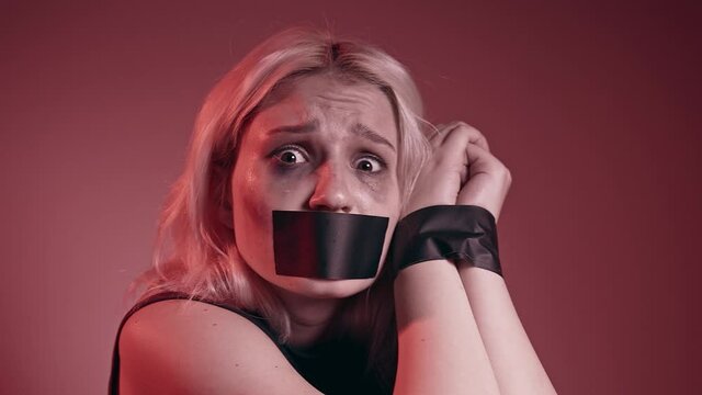 Frightened woman sadly looking into camera, victim of abuse