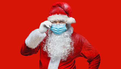 Portrait of a Santa Claus in a breathing mask on the red background