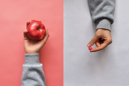 Food additives and an Apple in people's hands. Choosing between vitamins in tablets and vitamins in fruits