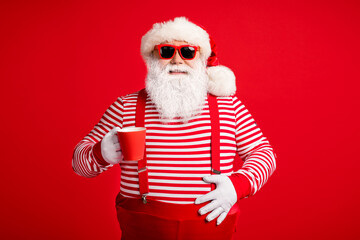 Fototapeta na wymiar Portrait of his he nice handsome attractive cheerful Santa father drinking cacao eggnog festal day touching abdomen isolated bright vivid shine vibrant red color background
