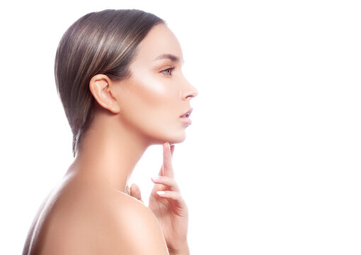 Beauty model woman profle portrait. Healthy skin, touching lips, nude make-up. Copy space on white background
