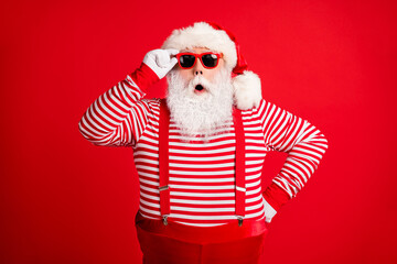 Fototapeta na wymiar Portrait of his he nice handsome amazed wondered grey-haired Santa wearing touching sunglasses winter incredible bargain isolated over bright vivid shine vibrant red color background