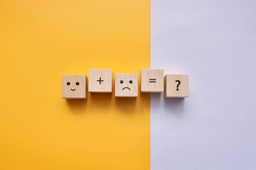 Wooden cubes with the image of a sad and joyful face. happy and joyful person together