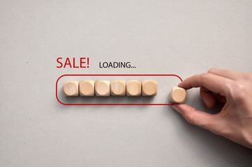 Wooden cubes in the form of a loading battery and the inscription: sale, loading. The beginning of...