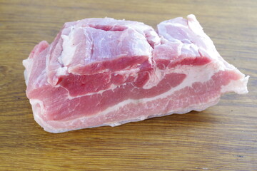 raw bacon with parsley on white plate