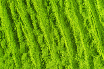 Matcha powder background. Green tea texture close up, selective focus