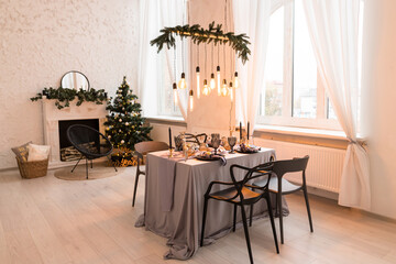 Luxurious expensive light interior in a royal style decorated with table, tree and fireplace. Concept of Christmas and New Year