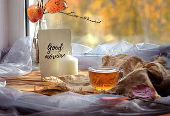 Home comfort, a beautiful transparent glass Cup full of tea on the background of the autumn landscape. Good morning.