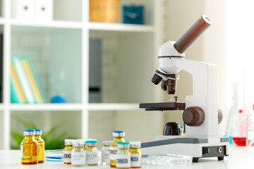 Vaccine bottles and microscope on table in a scientific lab