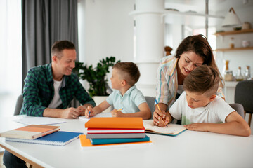 Parents helping the kids with their homework. Litlle boys learning at home.