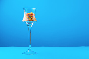 Glass containers with colorful candies against blue background