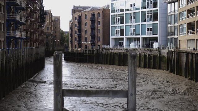 View above a muddy canal surrounded by colourful buildings from London, UK