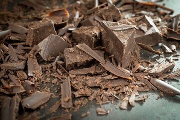 Pieces of dark chocolate and cocoa beans in composition on old background
