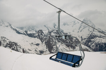 ski chair lift ropeway at the ski resort, view from the funicular to the mountains