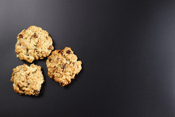 homemade oatmeal cookies with raisins on a black background. Copy space for text