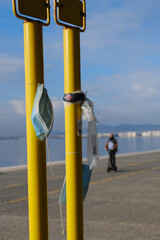 Masks hanging out from yellow poles in the waterfront of Thessaloniki, Greece during lock down curfew