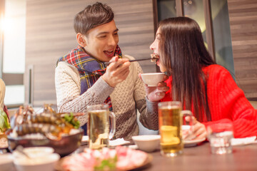 Young man is feeding his girfriend in restaurant