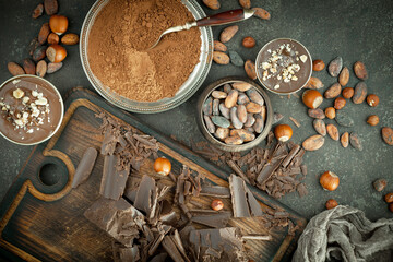 Pieces of dark chocolate and cocoa beans in composition on old background