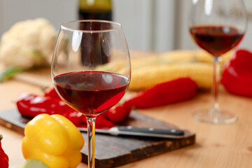 Two wine glasses with red wine on wooden kitchen counter