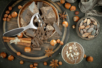 Fototapeta na wymiar Dark chocolate in a composition with cocoa beans and nuts, on an old background.