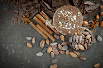 Pieces of dark chocolate and cocoa beans in composition on old background
