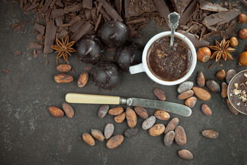 Hot chocolate on an old background in a composition with cocoa beans and nuts.
