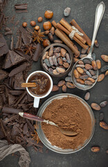 Dark chocolate in a composition with cocoa beans and nuts, on an old background.