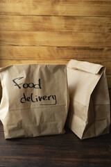 Craft packages with food delivery on dark wooden background