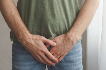 Man cover his groin by hands. Men's health. Urology problems male - obrazy, fototapety, plakaty