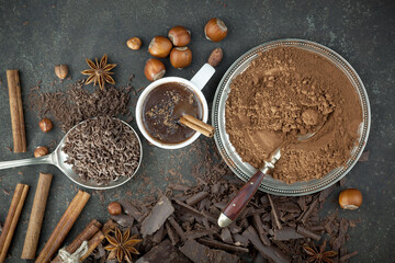 Pieces of dark chocolate and cocoa beans in composition on old background