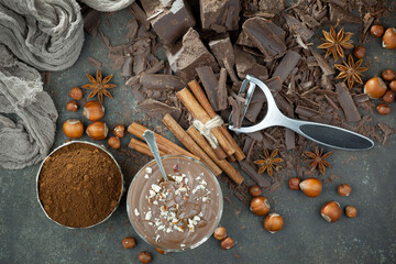Pieces of dark chocolate and cocoa beans in composition on old background