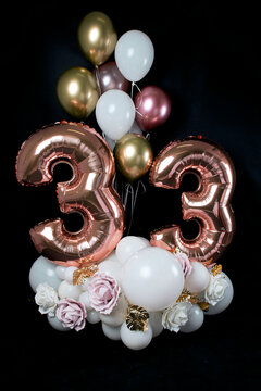 birthday card. Congratulations to 33 years old. Composition of balls and flowers on a black background