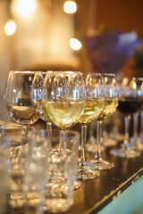 Glasses with white wine on counter prepared for guests.