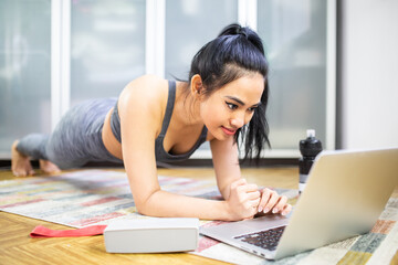 A woman doing exercise at home during the Covid-19 quarantine. Home workout. Online workout video tutorial