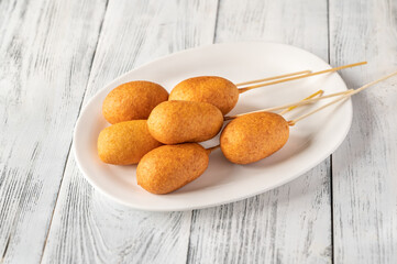 Corn dogs on white serving plate
