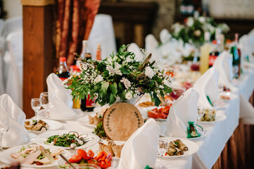 The wedding decor. The white flowers bouquet. Serving, setting table. Plate and silverware cutlery, napkin. Wedding table decoration.