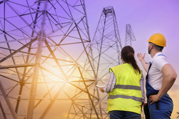 Professional engineers working on installation of electrical substation outdoors