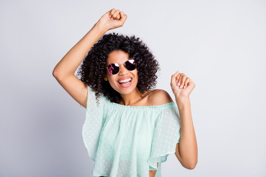 Photo portrait of happy black skinned girl curly hairstyle laughing dancing party in sunglass mint outfit isolated on grey color background